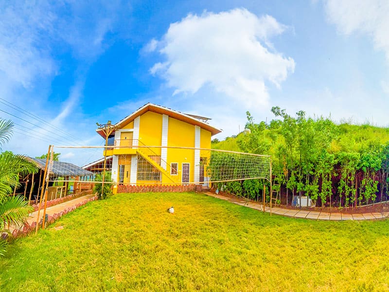 Lawn and sports area at Andur Lakeview Resort featuring open green space, outdoor games, and relaxing seating