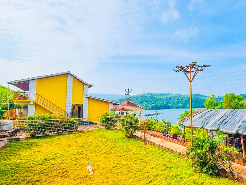 Lawn and sports area at Andur Lakeview Resort featuring open green space, outdoor games, and relaxing seating